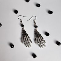 Silver skeleton hand earrings with black crystal beads and fish hooks.