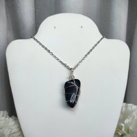 Obsidian wire wrapped pendant in silver with chain or cord.