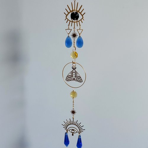Egyptian Eye of Ra suncatcher with brass eyes, moth and yellow and blue glass crystals.