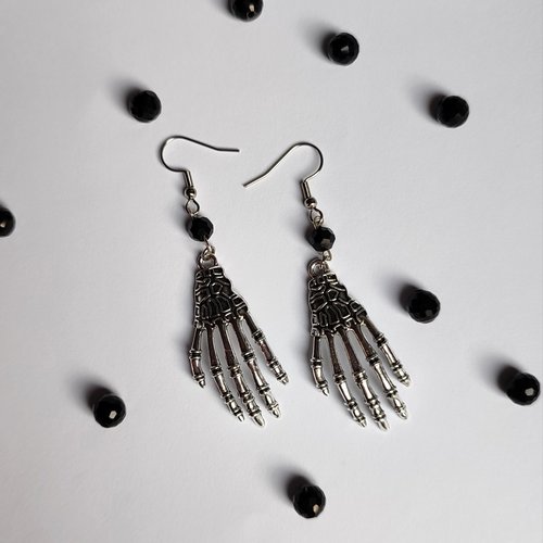 Silver skeleton hand earrings with black crystal beads and fish hooks.