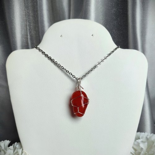 Carnelian pendant wrapped in silver plated wire with chain or cord.
