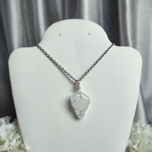 Clear quartz pendant wrapped in silver plated wire with chain or cord.