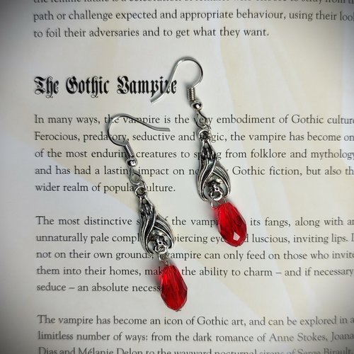 Gothic vampire bat earrings with red or black bead drops.