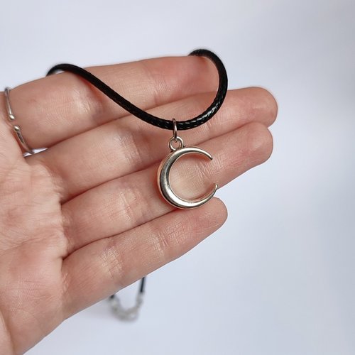 Silver crescent moon choker necklace on black cord.