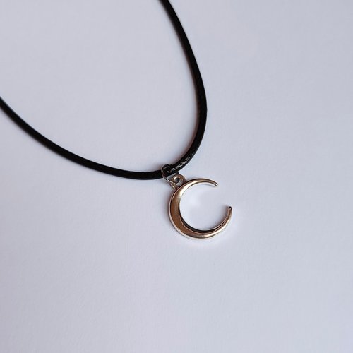 Silver crescent moon choker necklace on black cord.