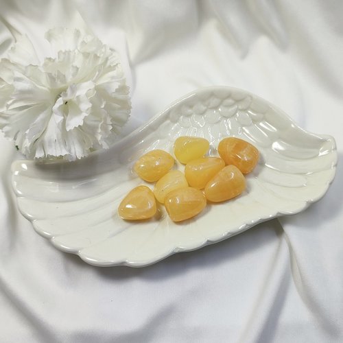 Orange calcite polished tumblestone measuring 20mm-30mm.