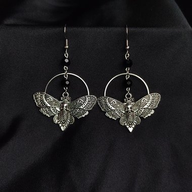 Silver death mask earrings with metal ring and black crystal beads.