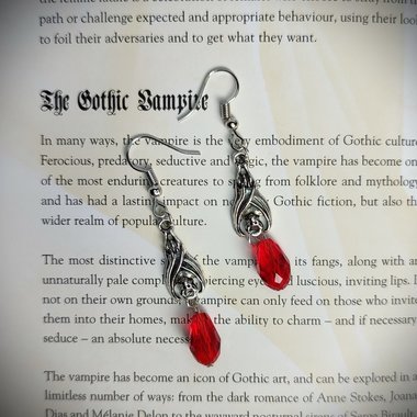 Gothic vampire bat earrings with red or black bead drops.