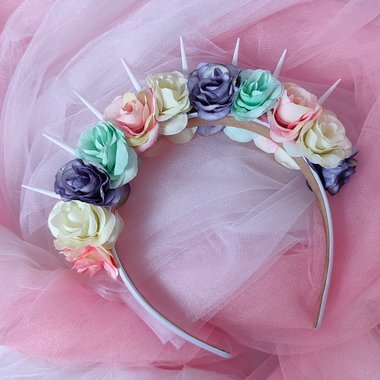 Bella Unicorn headband with white spikes and pastel pink, green, purple and white flowers.